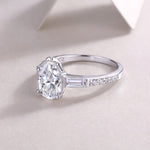 CARISSIE pear moissanite ring resting on surface, emphasizing the elongated silhouette and detailed shoulder pave work