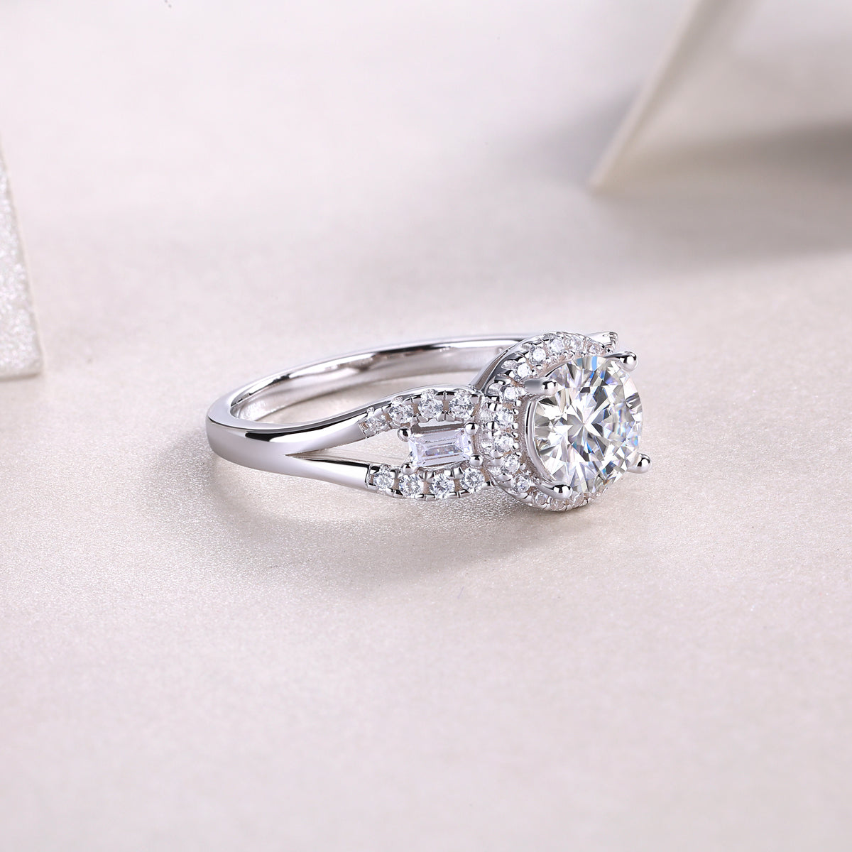 CARISSIE round moissanite halo engagement ring three-quarter perspective, highlighting the width of the band and the arrangement of accent stones