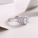 CARISSIE round moissanite halo engagement ring diagonal close-up, emphasizing intricate leaf design on shoulders