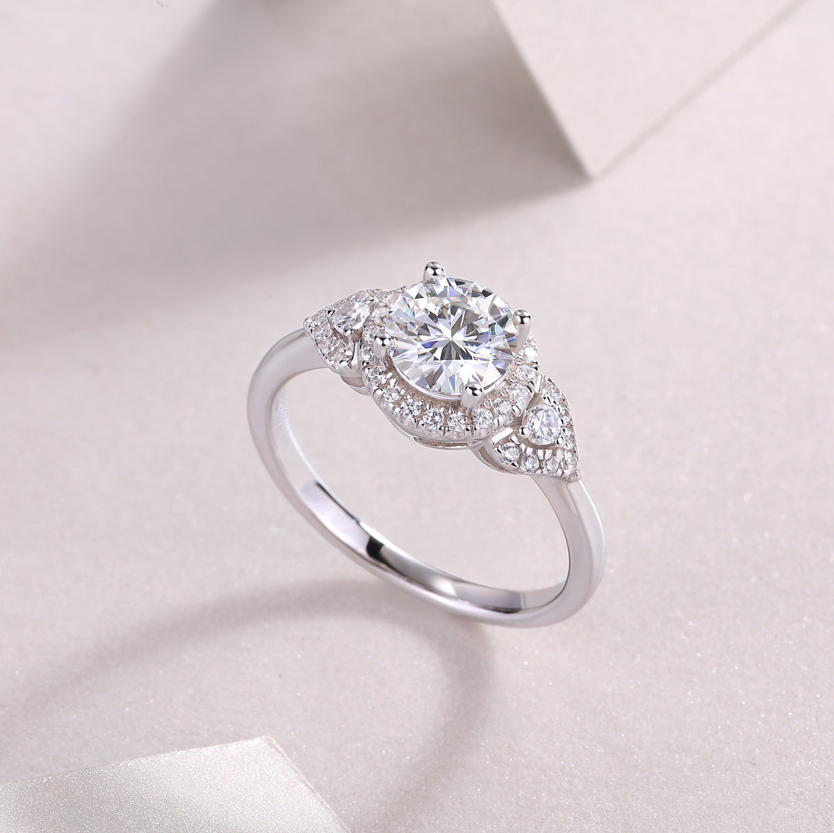 CARISSIE round moissanite halo engagement ring angled studio shot, capturing light reflection on stones and metal