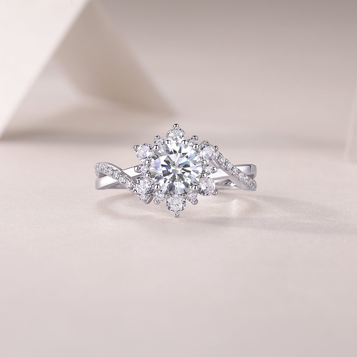 CARISSIE round moissanite halo engagement ring, lifestyle shot on soft fabric showing the interplay of light on the stones