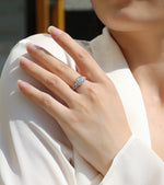 CARISSIE cushion moissanite halo ring on model, hand resting on shoulder highlighting double halo design and white metal finish
