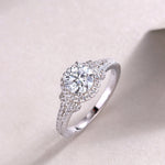 CARISSIE round moissanite ring lifestyle shot on textured surface capturing the brilliance of the stones in natural light