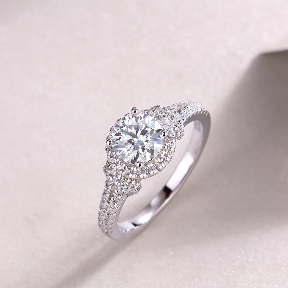 CARISSIE round moissanite ring lifestyle shot on textured surface capturing the brilliance of the stones in natural light