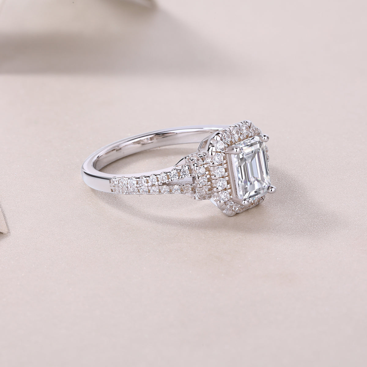 CARISSIE emerald cut moissanite halo ring diagonal angle, capturing light reflection on prongs and band
