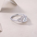 CARISSIE round moissanite halo ring on soft fabric surface, side angle highlighting the delicate pavé details on the tapered band