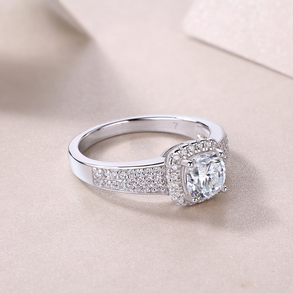 CARISSIE cushion moissanite halo wedding band three-quarter angle on fabric, showcasing the transition from paved shoulders to plain band