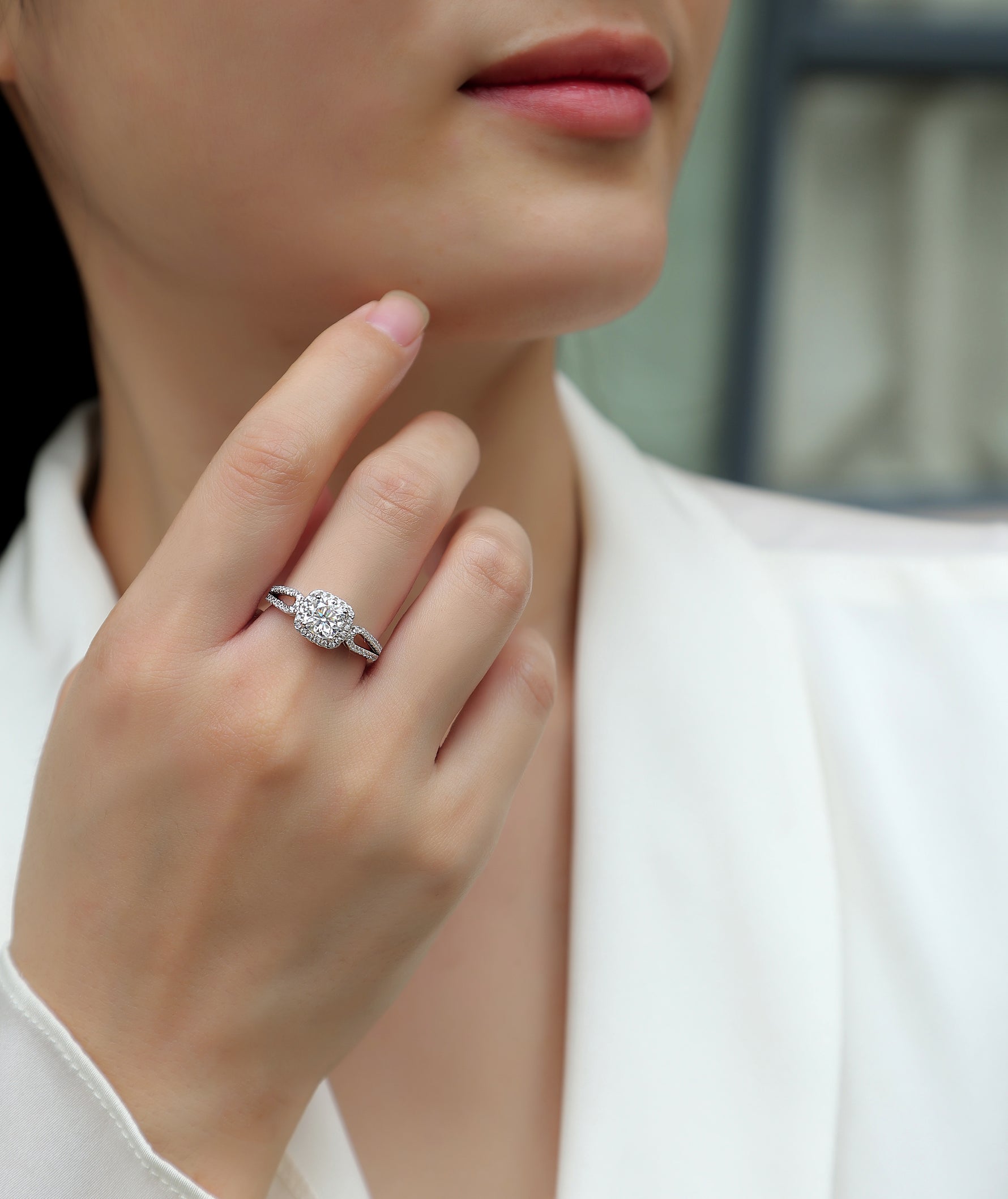 CARISSIE cushion moissanite halo ring on model, hand resting near chin showing double halo and split shank band