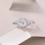 CARISSIE cushion moissanite halo ring flat lay, centered on beige background highlighting full face of the vintage design