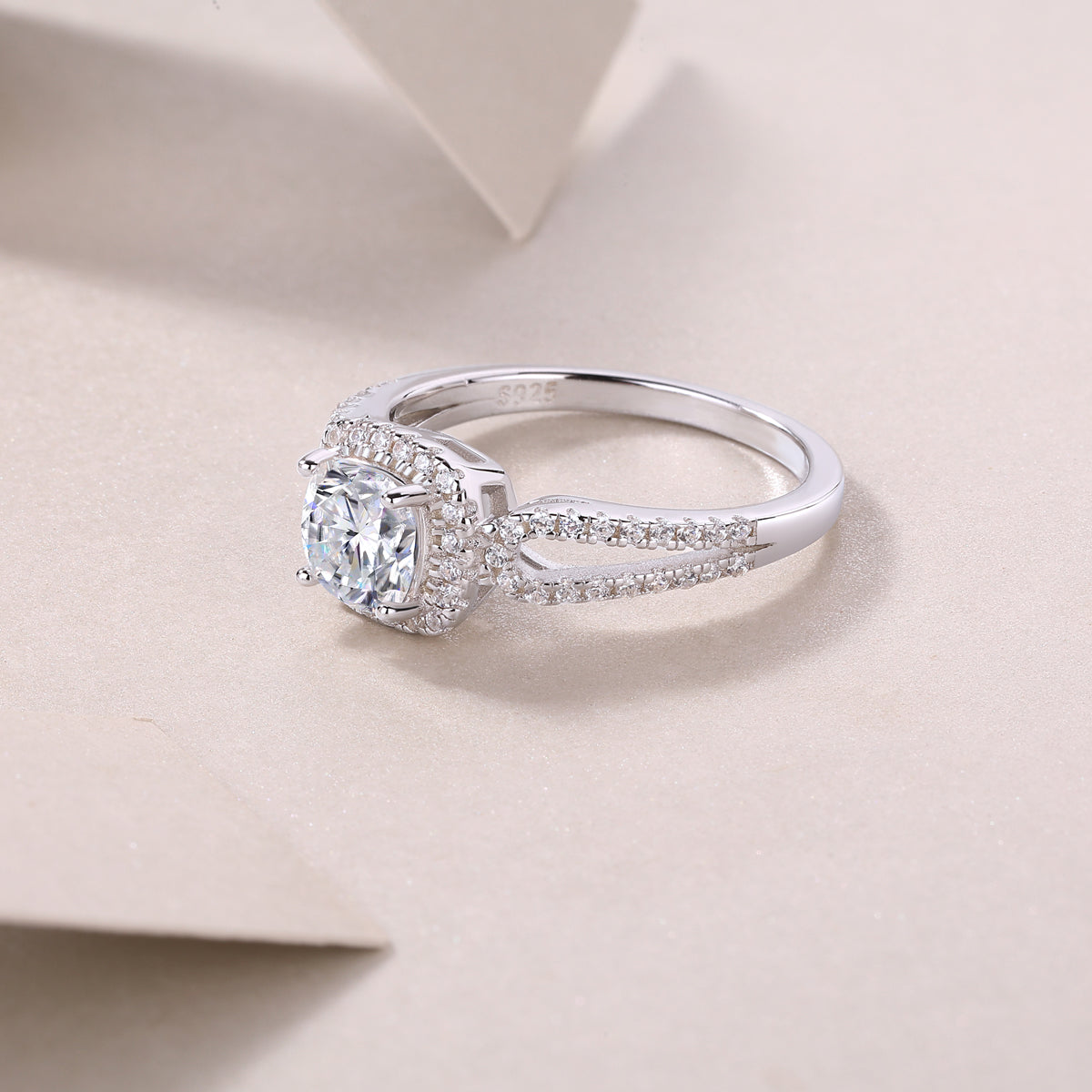 CARISSIE cushion moissanite halo ring lifestyle shot, resting on textured paper showing S925 stamp and side sparkle