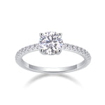 CARISSIE round moissanite solitaire ring studio shot, three-quarter angle displaying brilliant-cut stone and half-pavé shank