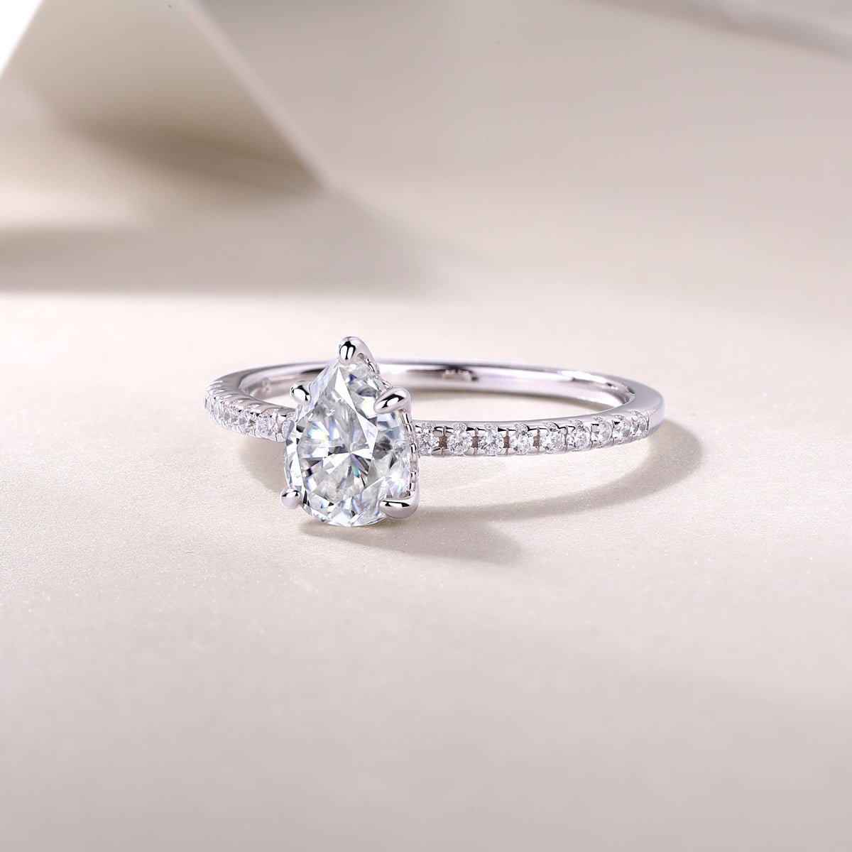 CARISSIE pear moissanite solitaire ring low-angle perspective, emphasizing the height of the prong setting