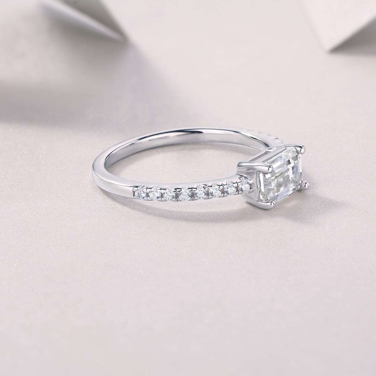 CARISSIE emerald cut solitaire engagement ring diagonal shot showcasing polished metal finish and stone clarity