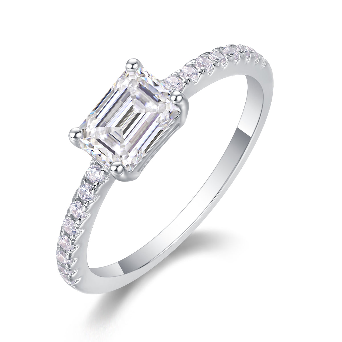 CARISSIE emerald cut solitaire engagement ring angled view highlighting four-prong setting and round accent stones