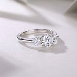 CARISSIE round moissanite solitaire ring, diagonal angle showcasing the curvature of the band and brilliance of the gems