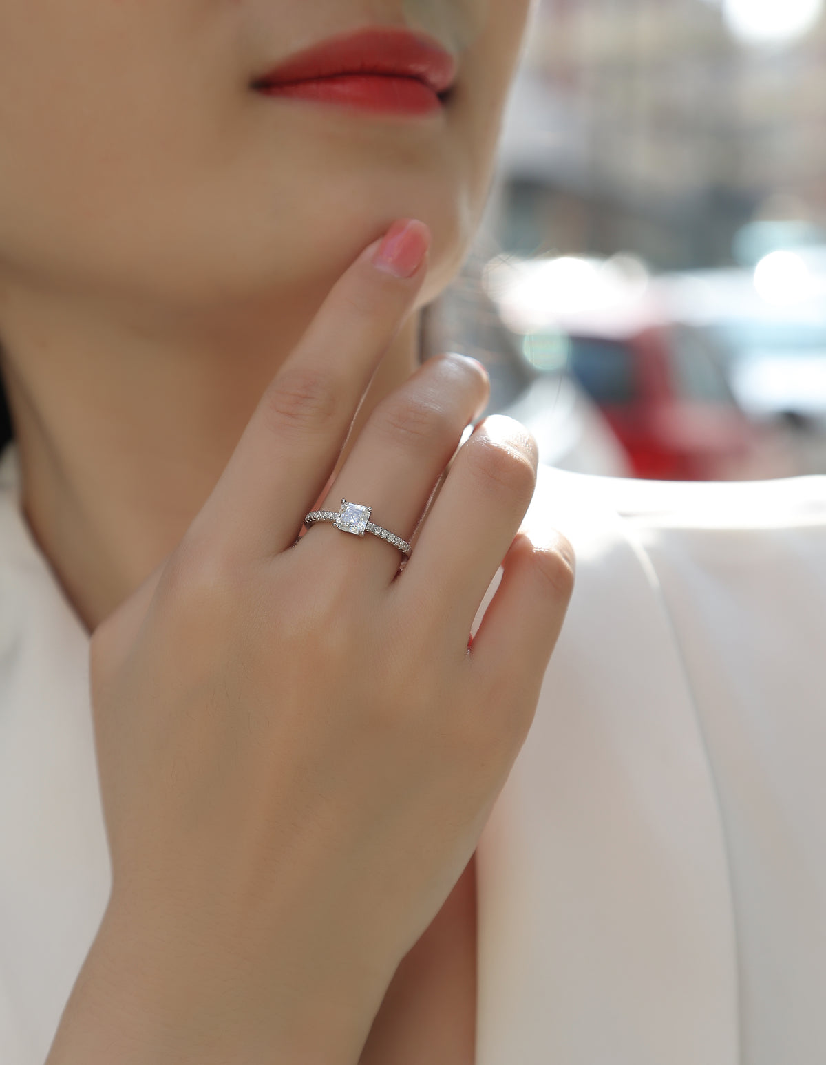 CARISSIE Asscher solitaire engagement ring worn on finger, highlighting the side profile of the accent stones and four-prong setting