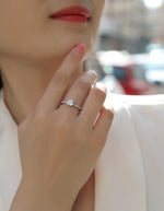 CARISSIE Asscher solitaire engagement ring worn on finger, highlighting the side profile of the accent stones and four-prong setting