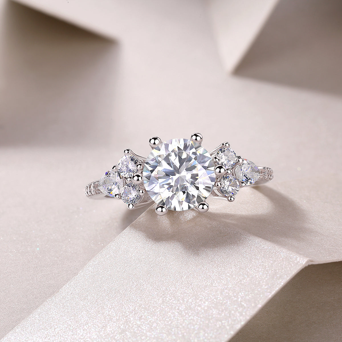CARISSIE round moissanite solitaire ring resting on textured paper, capturing light reflection on mixed cuts