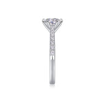 CARISSIE round moissanite solitaire ring, vertical angle showcasing the tapered shank and pave accent stones