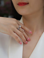 CARISSIE round moissanite solitaire ring lifestyle shot, worn on finger with pink manicure near collarbone