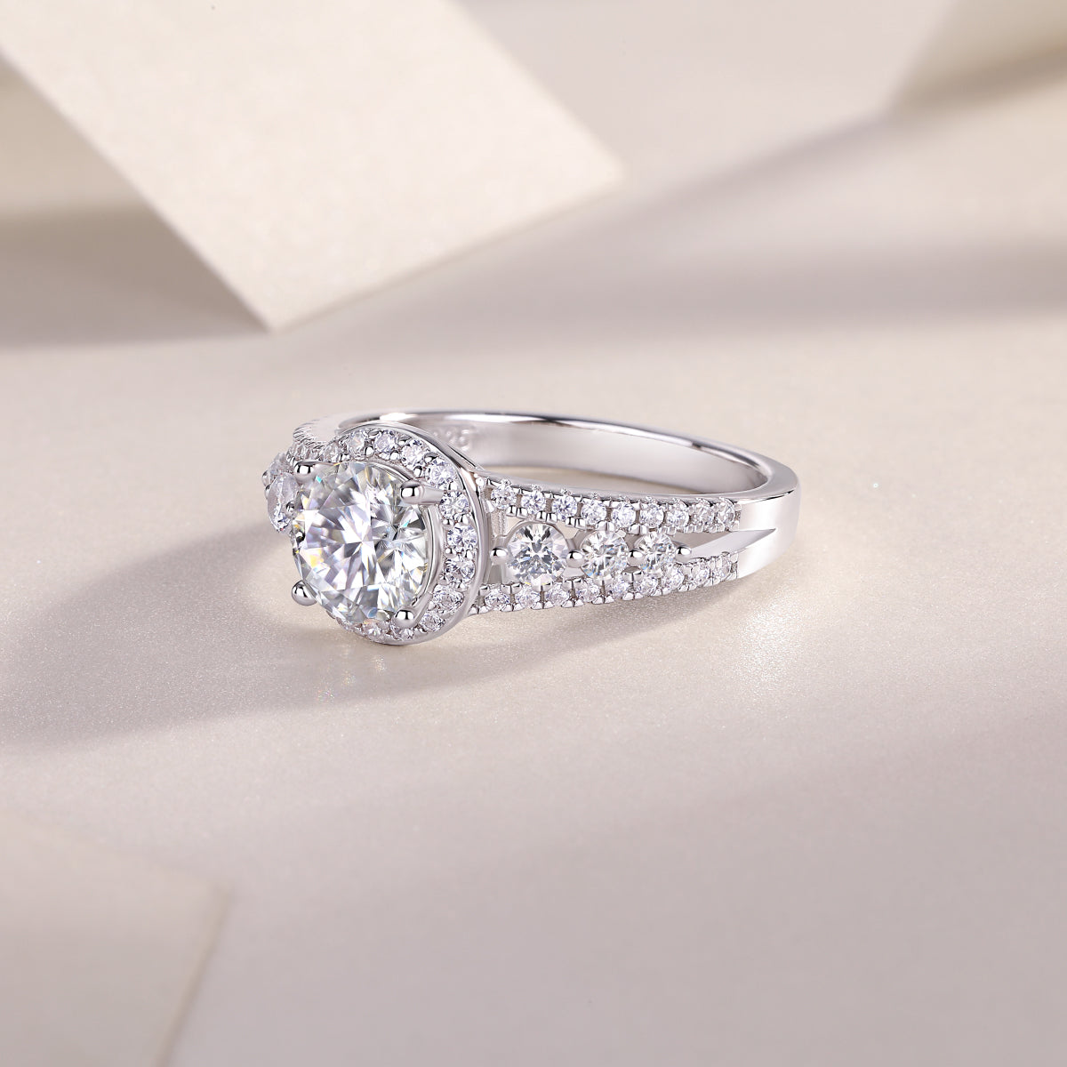 CARISSIE round moissanite solitaire ring, close-up angle focusing on the high-polish silver-tone metal and diamond accents