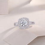 CARISSIE round moissanite halo ring, lifestyle shot on soft fabric displaying the sparkle of the silver-tone metal