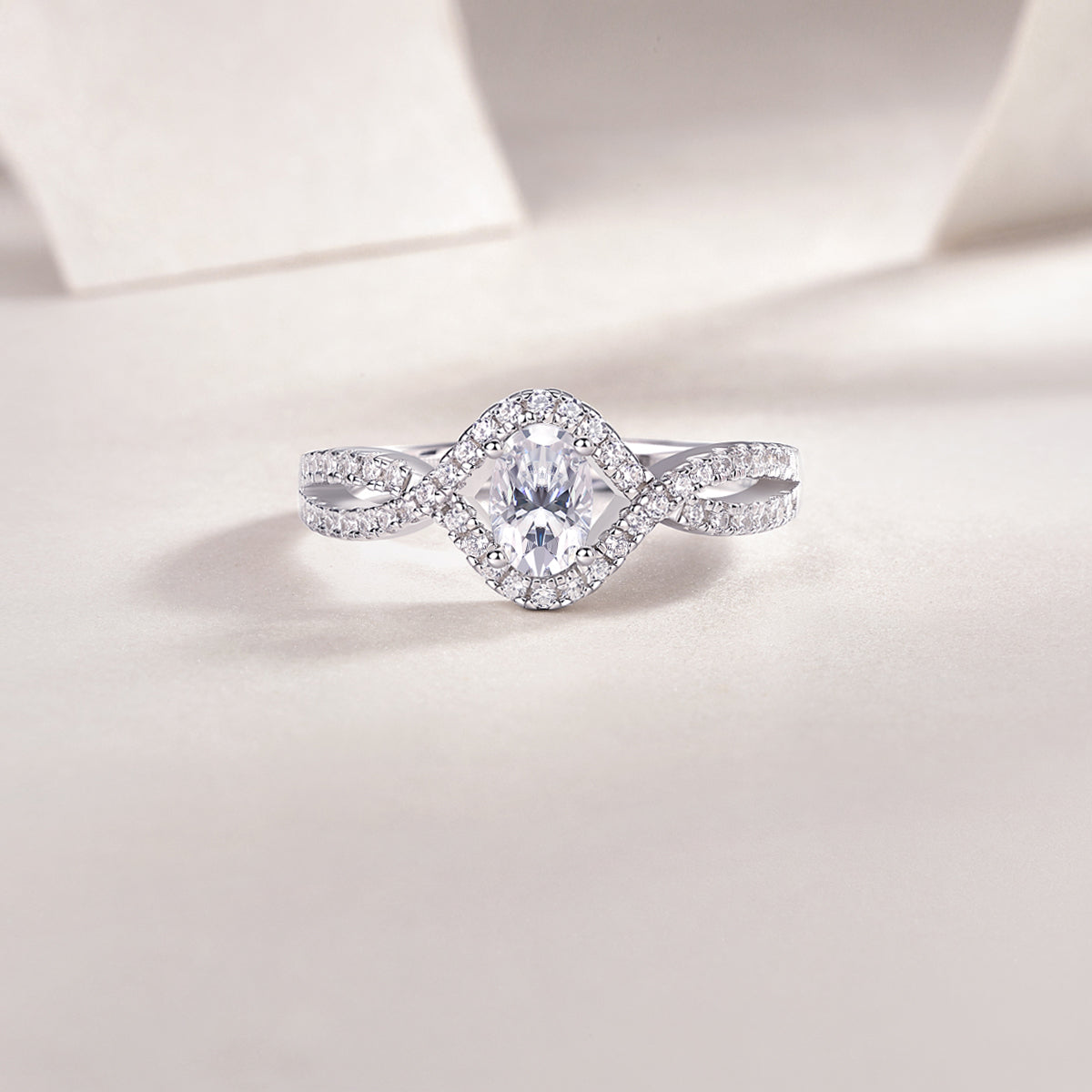 CARISSIE oval moissanite ring straight-on close-up, emphasizing symmetrical twist and brilliance of the main stone