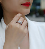 CARISSIE round moissanite halo ring worn by a woman touching her chin, close-up of the sparkling diamond details