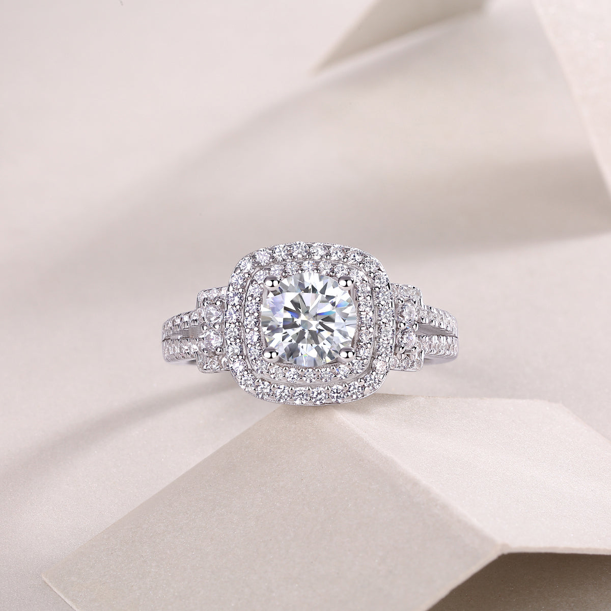 CARISSIE round moissanite halo ring, top-down perspective on soft folds emphasizing the symmetrical cushion-shaped halo
