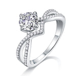 CARISSIE round moissanite solitaire ring, angled view showing split shank band with pavé accents and four-prong setting