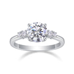 CARISSIE round moissanite solitaire ring, direct front view highlighting the brilliant-cut centerpiece flanked by smaller stones