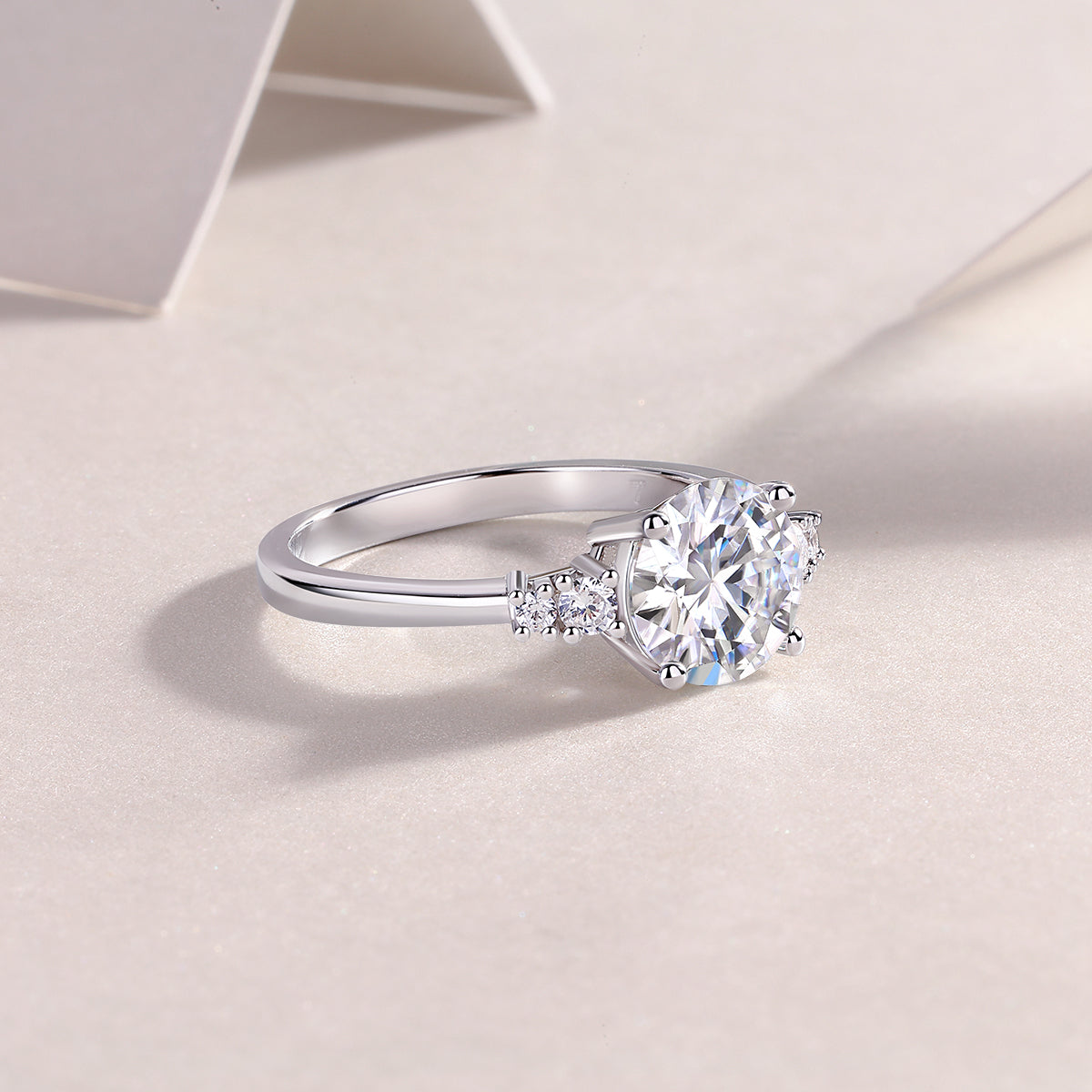CARISSIE round moissanite engagement ring, angled lifestyle perspective showing the polished silver finish and side stone details