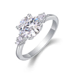 CARISSIE round moissanite engagement ring, angled view showing large center stone and asymmetric side clusters on silver band