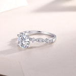 CARISSIE round moissanite solitaire ring, close-up side angle showing S925 stamp and detailed metalwork on shoulders