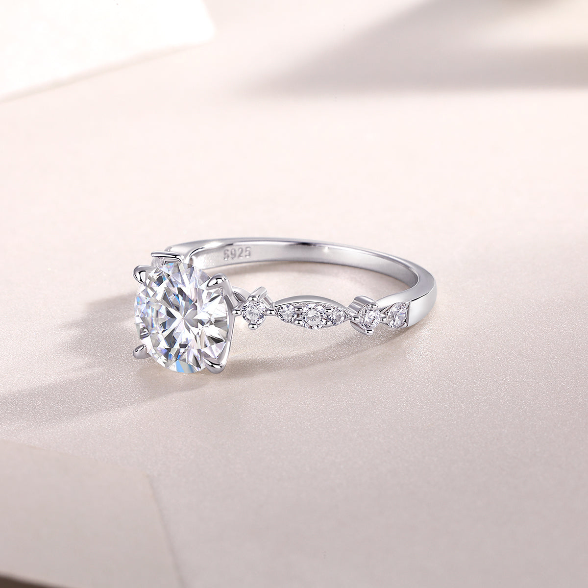 CARISSIE round moissanite solitaire ring, close-up side angle showing S925 stamp and detailed metalwork on shoulders