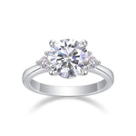 CARISSIE three-stone moissanite ring, front view highlighting symmetrical round brilliant cut gems and prong details