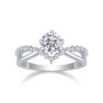 CARISSIE round moissanite solitaire ring, front view displaying the four-prong basket and symmetrical diamond-encrusted band