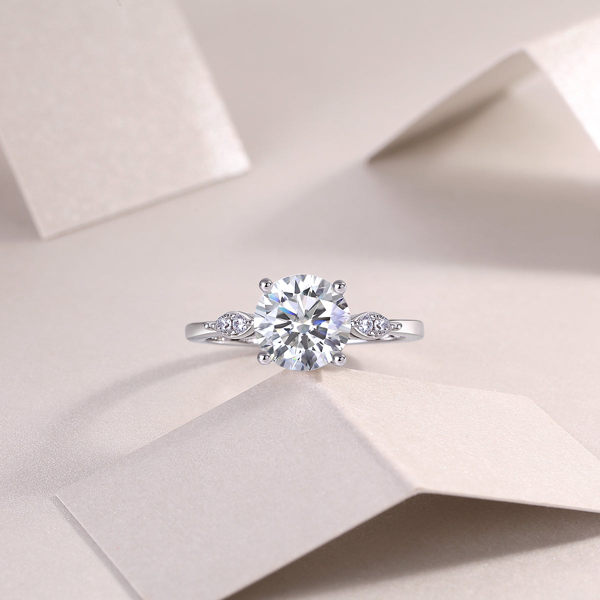 CARISSIE round moissanite solitaire ring, overhead view on soft background emphasizing symmetrical design and stone brilliance