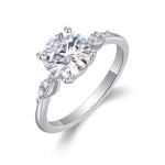 CARISSIE round moissanite solitaire ring, angled view showing split shank shoulders with accent stones and polished silver band