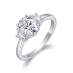 CARISSIE oval moissanite solitaire ring, angled view highlighting the brilliant center stone and side stones in a prong setting