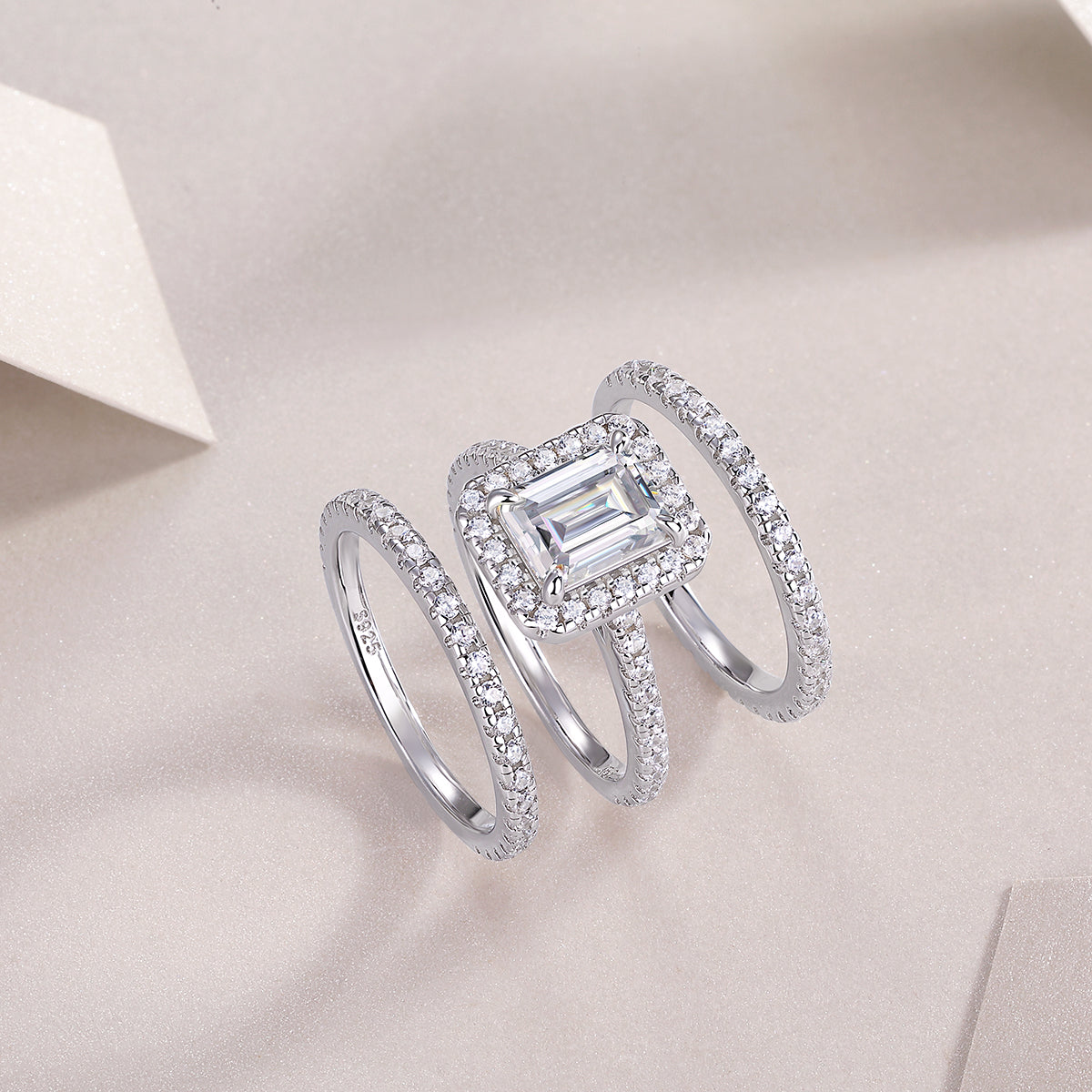 CARISSIE emerald cut moissanite halo ring studio shot, angled view highlighting the double halo and pavé bands