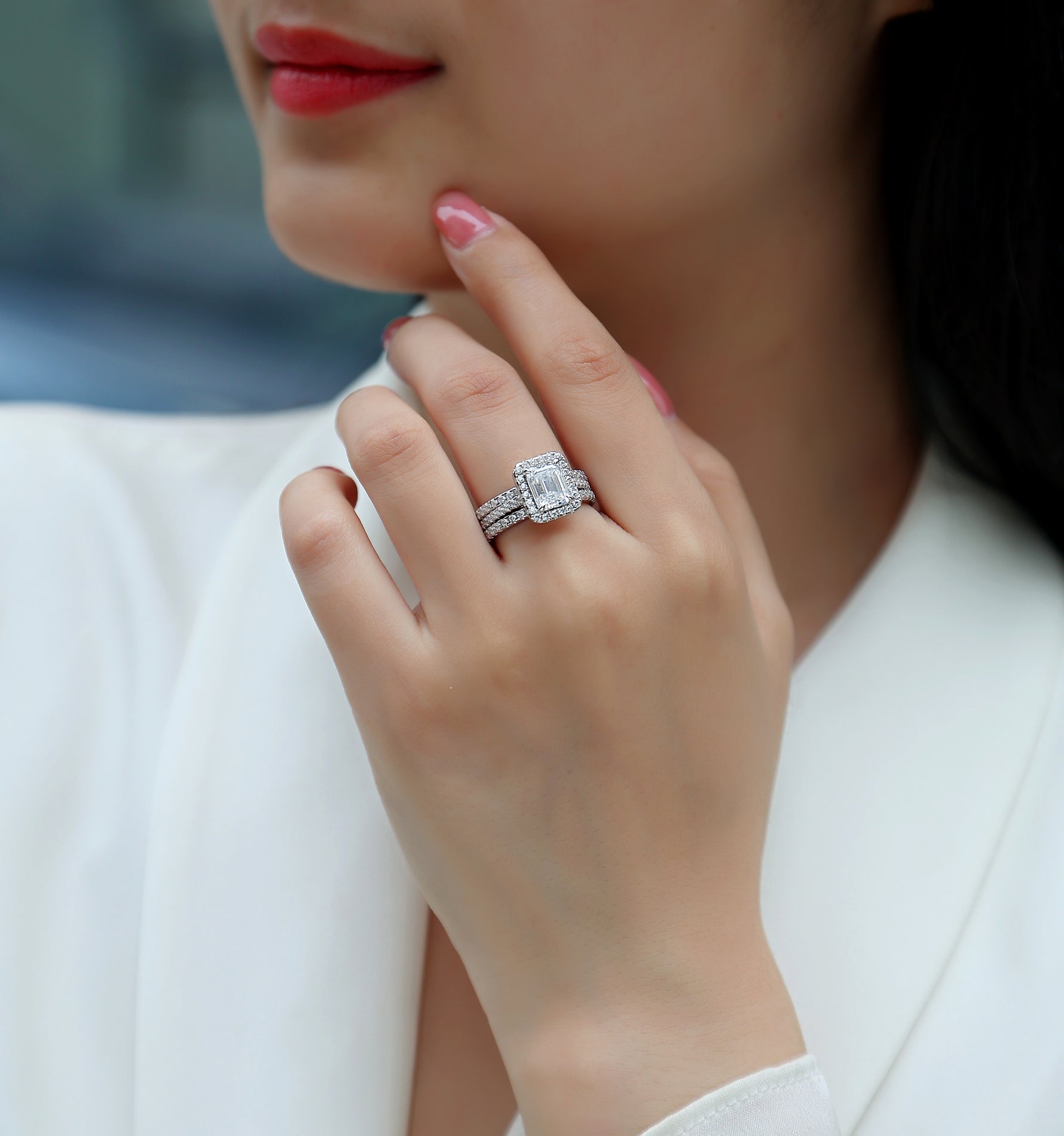CARISSIE emerald cut moissanite halo ring on model, showing elegant three-piece set worn against a white blazer