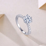CARISSIE round moissanite solitaire ring, diagonal angle showing interior metal stamp and transition to plain band