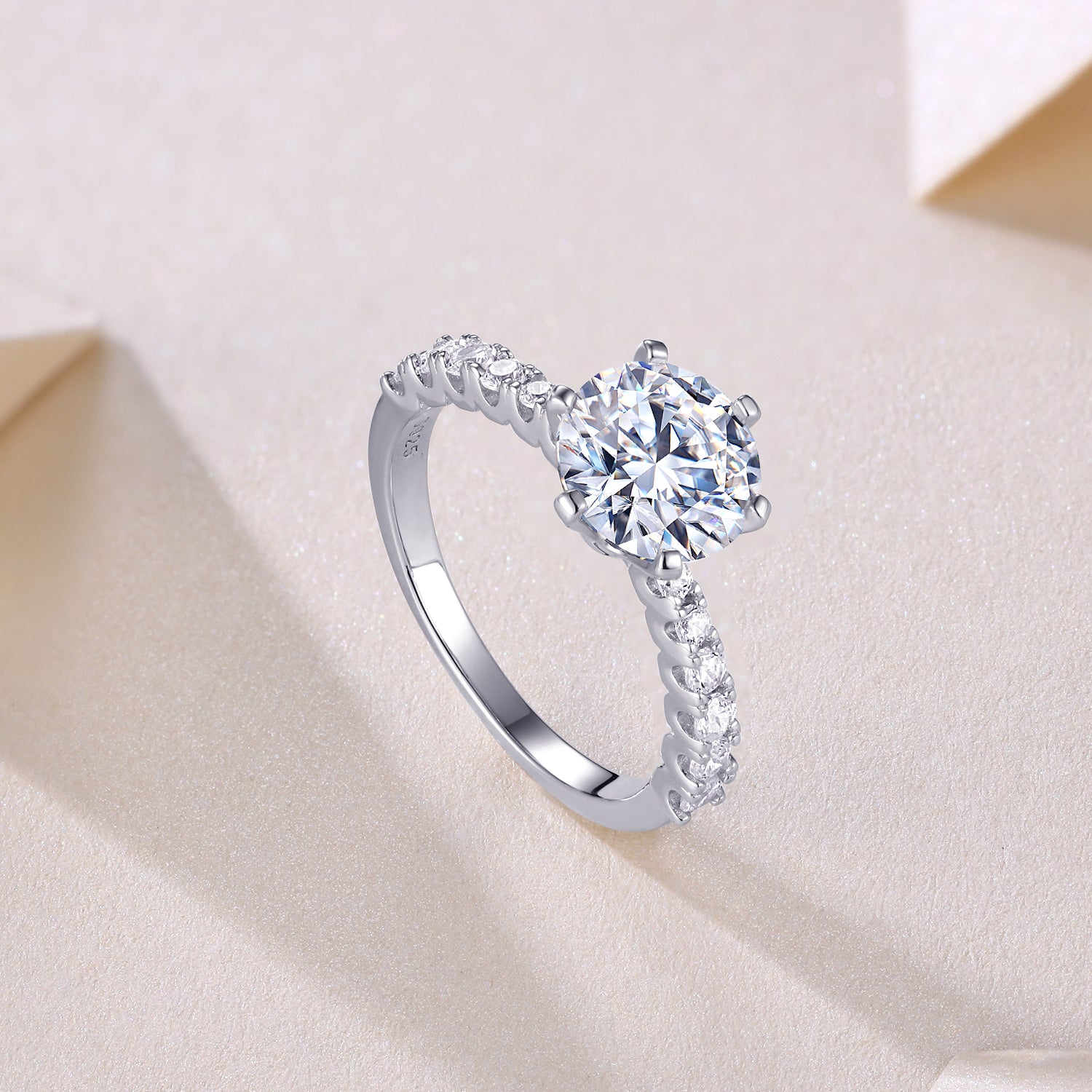CARISSIE round moissanite solitaire ring, diagonal angle showing interior metal stamp and transition to plain band