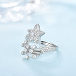 CARISSIE round moissanite cluster engagement ring, side profile showing the curved shooting star tails and pavé band