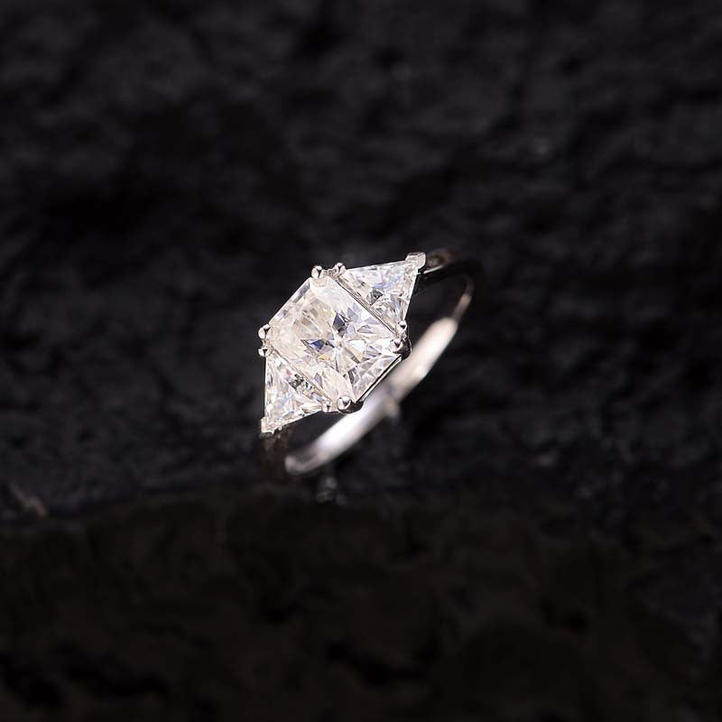 CARISSIE radiant solitaire engagement ring, angled top-down shot highlighting geometric shape and brilliance against textured background