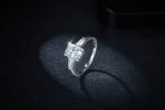 CARISSIE radiant cut engagement ring, angled view showing sparkling center stone and tapered baguette sides on dark glitter background