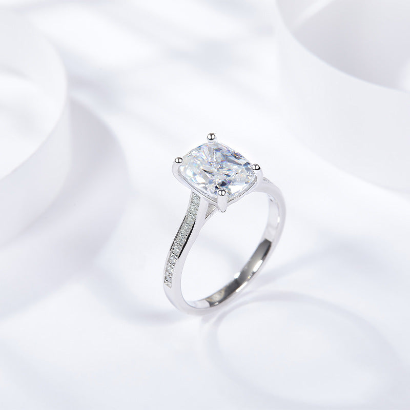 CARISSIE cushion solitaire engagement ring, angled perspective showing the curved shoulders and polished white metal band