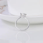 CARISSIE round moissanite solitaire ring, vertical angle displaying six-prong setting height and diamond accents