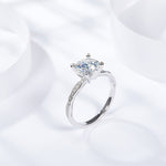 CARISSIE round moissanite solitaire ring, lifestyle shot on white surface emphasizing high polish finish and sparkle